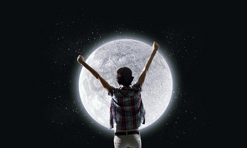 满月。举起双手仰望天空中月亮的年轻女子的背影