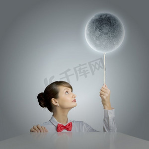 有月亮的女人。年轻女子手持月球星球颜色的气球