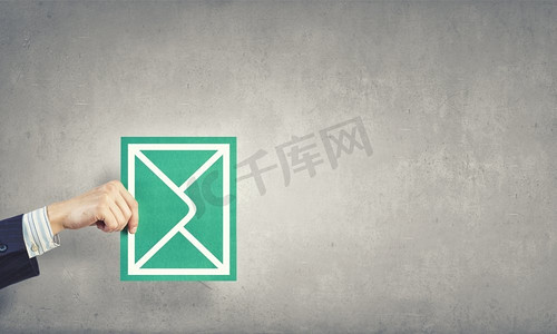 绿色明信片卡片摄影照片_发电子邮件。代表电子邮件概念的手持信封卡片