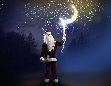 月亮装饰摄影照片_圣诞老人。圣诞老人用绳子牵着夜空中的月亮