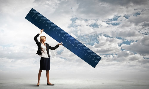 年轻的女商人用大尺子测量某事.