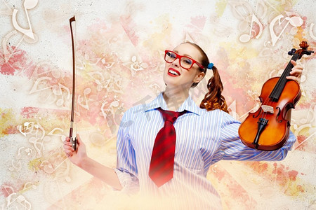 年轻的女小提琴家。彩色背景下拿着小提琴的年轻滑稽女子形象