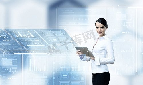 使用现代科技的女性。在高科技蓝色背景下使用平板电脑的女商人