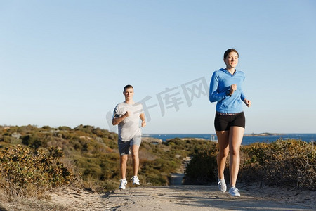 健身模型摄影照片_体育跑步者在海滩慢跑锻炼出与她的伙伴.适合女性健身模型慢跑沿着海洋与她的伙伴
