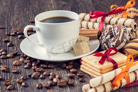 什锦饼干和一杯咖啡。桌上有各式各样的饼干和一杯白咖啡