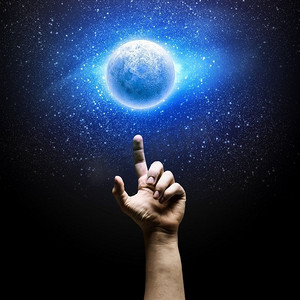 手指天空摄影照片_月亮的图像。人类手指着太空中的月亮