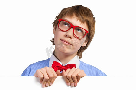 戴红眼镜的男孩拿着白色方块。小男孩若有所思地微笑着拿着白色方块的形象。刊登广告的地点