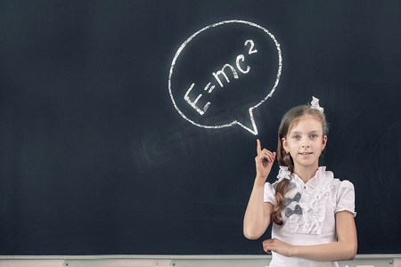 黑板上的女学生用手指指着科学公式。物理公式
