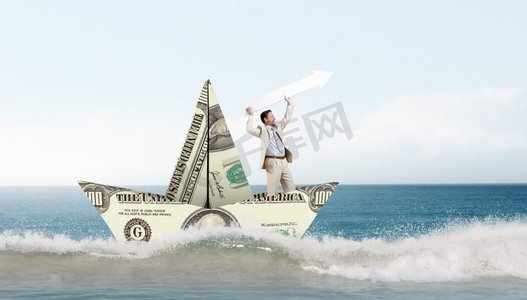 商人在美元钞票制成的船。成功的商人航行在美元船在金融海