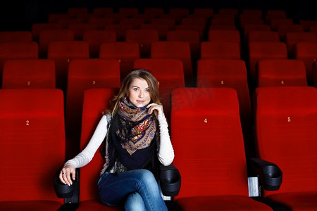 年轻女孩坐在电影院里看电影
