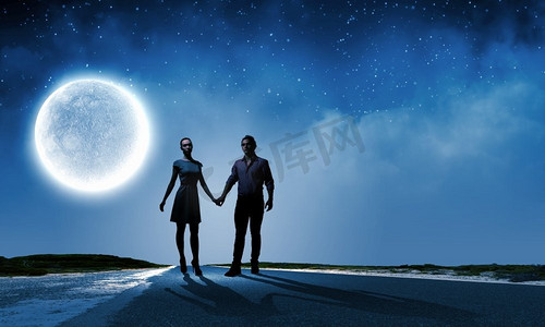 浪漫的约会。背景大月亮映衬下的情侣剪影