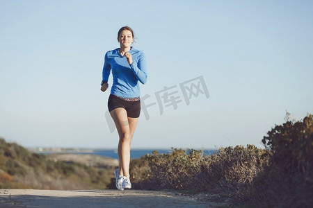 健身模型摄影照片_体育跑步者慢跑在海滩锻炼出来。适合女性健身模型慢跑沿海洋