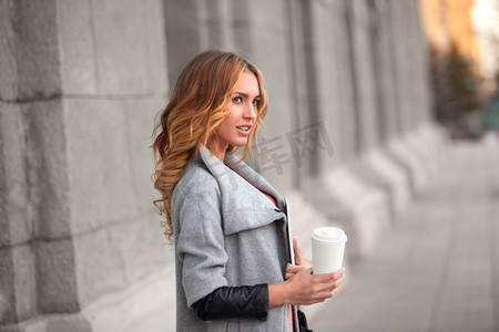 一个漂亮的女人和一杯咖啡来对抗城市的场景。