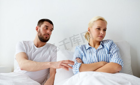 人、关系困难和家庭观念-不幸福的夫妻在家中床上发生冲突。不幸福的夫妇在家中床上发生冲突
