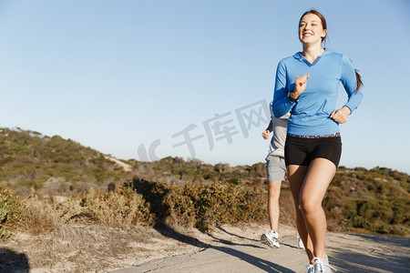 健身模型摄影照片_体育跑步者在海滩慢跑锻炼出与她的伙伴.适合女性健身模型慢跑沿着海洋与她的伙伴