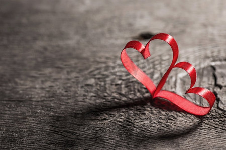 木质背景上的两个红丝带心形，情人节概念