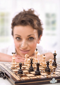 象棋游戏摄影照片_一位手持象棋的年轻女子的肖像