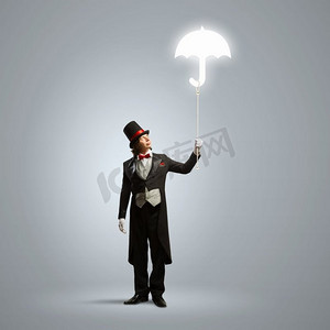 手撑摄影照片_戴帽子的魔术师。戴着帽子撑着伞的巫师形象