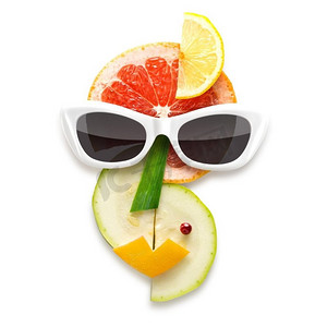 别致的食物概念立体主义风格的女性戴着水果和蔬菜制成的太阳镜，孤立在白色上。