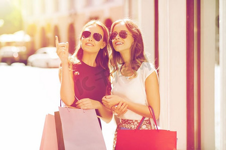 销售、消费主义与人的观念--城市里提着购物袋指手画脚的快乐年轻女性。城市里提着购物袋的幸福女人