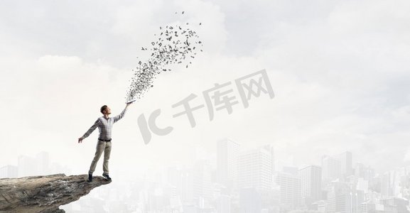 书籍能让你超越其他人。一位年轻英俊的男士随手拿着书