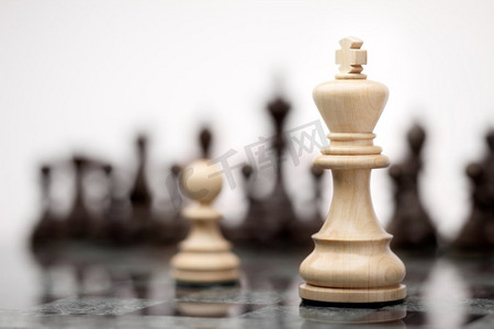 领导力和勇敢观；白色木质单卒对抗棋盘上的白色国王。
