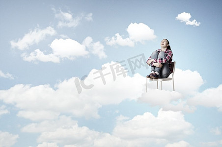 天堂里的女人。年轻女子坐在椅子上云高在天空