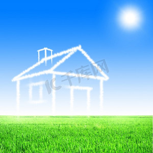 绿地产摄影照片_云彩的房子在蓝天反对绿草的背景.