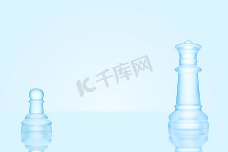 水火对抗摄影照片_领导力和勇敢的概念；在棋盘上，一个冰冷的磨砂的单一棋子与女王对抗。