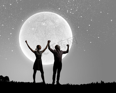 浪漫的一对站在月光下的年轻浪漫夫妇的剪影