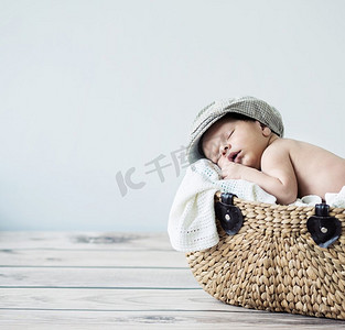 睡在柳条篮子里的可爱小孩