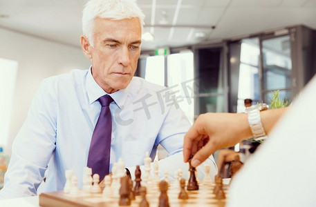 全新玩法摄影照片_两个在办公室里下棋的商人。战略玩法
