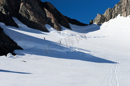 登山徒步的人摄影照片_新西兰一群人走在新西兰山区的雪