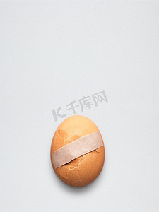 创意医药保健理念，将膏药贴在碎鸡蛋上。