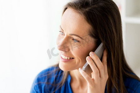 科技、沟通与人的观念--幸福微笑的女人用智能手机打电话的特写。快乐女人在智能手机上通话的特写