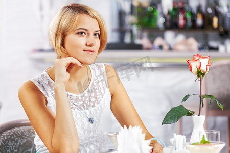 咖啡馆里的可爱女孩。坐在咖啡馆里的年轻漂亮女子的肖像