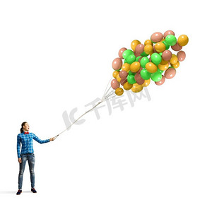 拿着气球的女人。穿着休闲衣服的年轻女子手里拿着一堆彩色气球