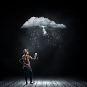 气球雨摄影照片_雨中的女人。一名年轻女子随意地抱着绳索上的雨云