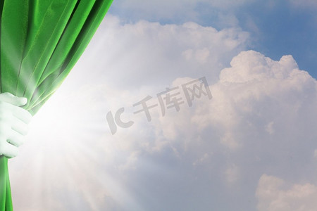 绿色窗帘摄影照片_拉开帷幕。手拉开绿色窗帘的特写。文本的位置