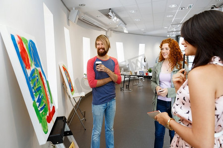 年轻人站在画廊里凝视着艺术品。站在画廊里凝视抽象艺术品的年轻人