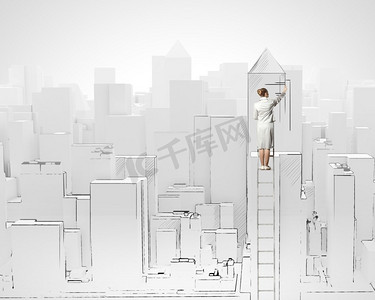 建设理念。女商人站在梯子上画建筑的背影