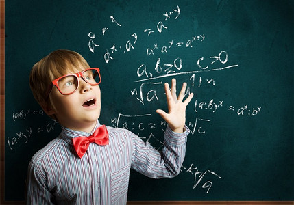 聪明的学生天才男孩在红色眼镜黑板附近的公式