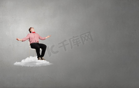 心烦意乱的年轻人坐在云端的椅子上。处于绝望之中