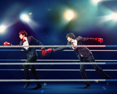 两个年轻的商人在打拳击。两个年轻的商人在黑暗的背景下打拳。概念拼贴