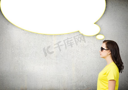 黄色聊天框摄影照片_聊天的概念。年轻女子穿着休闲装，上面空洞地说着气泡