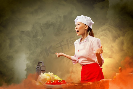 愤怒的亚裔女厨师。亚洲女厨师对具有闪亮效果的颜色背景感到愤怒