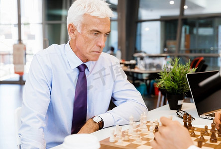 全新玩法摄影照片_两个在办公室里下棋的商人。战略玩法