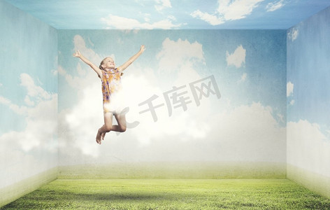 人飞在天上摄影照片_快活而快乐。可爱快乐的小女孩在天上跳得很高
