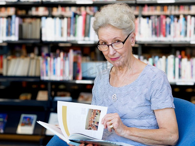 从容地摄影照片_一位老妇人在图书馆看书。从容地读新书