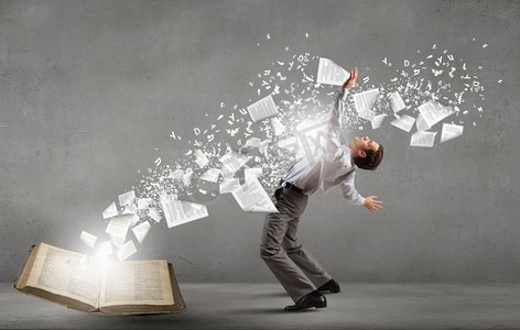 年轻人弯腰躲避从书中飞出的人物.